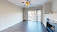 Located at 508 Pride Avenue in Herndon, Virginia, this three-story home offers a well-organized layout across multiple levels, with two bedrooms, two full bathrooms, a dedicated laundry room, pantry, and ample closet storage throughout. The entry level welcomes you with light tile flooring, a clean hallway, and a carpeted staircase with a white-painted banister leading to the main living areas above. The main floor serves as the heart of the home, featuring a bright living room with hardwood-style flooring, crown molding, a ceiling fan, and a striking granite-surround fireplace as the focal point. A sliding glass door opens to an outdoor deck, bringing in natural light and outdoor views. The adjacent kitchen is well-appointed with white cabinetry, granite countertops, stainless steel appliances including a gas range, microwave, and refrigerator, plus a dining area nearby. The upper floor houses both bedrooms, each carpeted and equipped with ceiling fans. The primary bedroom is generously sized with a window overlooking the surroundings. Both bathrooms feature wood-style flooring, white vanities, and tub-shower combinations. Multiple staircases, bonus rooms, and closets throughout the home add to its practical, functional appeal.