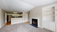 Located at 1525 Grayson Hwy in Grayson, GA, this two-bedroom, two-bathroom residence offers a well-designed single-floor layout with a warm, neutral palette throughout. The open-concept living area is anchored by a classic white-mantled fireplace and features vaulted ceilings that enhance the sense of volume and airiness. Plush carpeting runs throughout the main living spaces, adding comfort underfoot. The living area flows seamlessly toward the kitchen, which is separated by a convenient breakfast bar. The kitchen is well-appointed with white raised-panel cabinetry, dark countertops, a grey subway tile backsplash, stainless steel appliances, and wood-look flooring. Both bedrooms are generously sized with plush carpeting and large windows that invite natural light and outdoor views. The primary bedroom includes a spacious walk-in closet, while a second bedroom offers direct balcony access. Each bathroom features a tub/shower combination with white tile surround, wood-look flooring, and clean, functional finishes. The balcony access and well-placed windows provide a connection to the surrounding greenery, creating a bright and inviting living environment throughout.