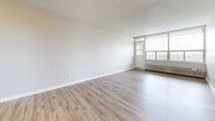Located at 78 Braemar Dr in Brampton, Ontario, this 2-bedroom unit offers a clean, functional layout across a single floor. Light-toned hardwood-style flooring runs seamlessly throughout, lending a cohesive and modern feel to the entire space.

The living room is a standout feature, anchored by expansive floor-to-ceiling windows that frame open city views and flood the room with natural light. A balcony door provides direct outdoor access, enhancing the airy, open ambiance. Baseboard heating units line the window walls, ensuring year-round comfort.

The primary bedroom is generously proportioned, featuring a large double closet alongside an additional single closet, offering ample built-in storage. The second bedroom also benefits from natural light through wide windows, with a baseboard heater and its own closet space, making it equally practical and comfortable.

Throughout the unit, neutral warm-beige walls create a calm, versatile backdrop. White trim, panel-style doors, and flush ceiling fixtures maintain a clean and consistent aesthetic. The entryway provides a clear transition into the main living area, contributing to the unit's efficient and well-organized flow. Overall, this space delivers a bright, understated, and move-in-ready environment suited for comfortable everyday living.