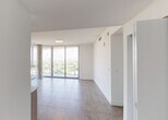 Located at 2900 SW 28th Lane in Miami's desirable Coconut Grove neighborhood, this modern high-rise unit offers a refined living experience defined by clean lines, contemporary finishes, and sweeping panoramic views of the Miami skyline and lush treetop canopy below. Large-format porcelain tile flooring runs throughout, complementing the bright, white walls and creating a cohesive, polished aesthetic.

The open-concept living and dining area is anchored by expansive floor-to-ceiling sliding glass doors that lead to a private balcony, flooding the interior with abundant natural light and providing unobstructed elevated views of the surrounding cityscape. The kitchen is well-appointed with light wood cabinetry, a glass tile backsplash, white quartz countertops, and a full suite of stainless steel appliances including a French door refrigerator, range, built-in microwave, and dishwasher. In-unit washer and dryer hookups offer added convenience.

The bedrooms are generously proportioned, each benefiting from floor-to-ceiling glass doors that frame the striking outdoor views. Ample closet space, including a walk-in closet, adds practical storage. The bathrooms are finished with modern floating vanities, clean white countertops, and large mirrors that enhance the sense of light and space throughout.