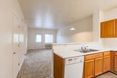Located at 1501 Almaden Expy in San Jose, CA, this single-floor residence offers three bedrooms, two bathrooms, and a practical, well-organized layout. The open-concept design connects the kitchen directly to the combined dining and living area, creating a cohesive and functional shared space. The kitchen is outfitted with warm honey-toned cabinetry, light countertops, a double-basin sink, a gas range, a dishwasher, and a full-size refrigerator, all finished with wood-look vinyl flooring. A peninsula counter separates the kitchen from the living area, which features soft carpeting, a pendant light fixture, and a wall-mounted AC unit, with natural light streaming in through a door and window overlooking greenery outside. The bedrooms are carpeted and bright, each with neutral walls and windows that bring in natural light. The primary bedroom is generously proportioned, offering ample space for furnishings. Both bathrooms feature tub-shower combinations, wood-look vinyl flooring, and clean white fixtures. One bathroom includes a single-sink vanity with warm wood cabinetry, while the second is equipped with safety grab bars. The overall ambiance is clean, neutral, and move-in ready.