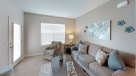 This single-floor residence offers a thoughtfully designed layout that balances comfort and functionality across its key living spaces. The entryway greets visitors with warm hardwood flooring, decorative wall art, and a bench, setting an inviting tone for the rest of the home.

The living room features a mix of hardwood and carpet flooring, neutral taupe walls, and large windows with horizontal blinds that allow generous natural light. The space comfortably accommodates a sofa, accent chair, and coffee table, creating an ideal gathering area.

The kitchen is outfitted with rich dark cabinetry, granite countertops, stainless steel appliances including a gas range, microwave, and refrigerator, along with hardwood flooring and recessed lighting. A peninsula counter provides additional prep and dining space.

Both bedrooms are carpeted and bright, each benefiting from multiple windows. The primary bedroom features an en-suite bathroom with a dual-sink vanity, granite countertops, dark cabinetry, and hardwood flooring. A second full bathroom mirrors this design with similar finishes. The consistent neutral palette with teal accents ties the entire residence together cohesively.