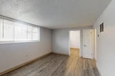 Located at 138 Jamesville Ave in Syracuse, NY, this 2-bedroom, 1-bathroom unit offers a practical and functional layout across a single floor. Wood-look luxury vinyl plank flooring runs throughout the space, complemented by neutral gray walls, white trim, and a textured popcorn ceiling that adds character to each room.

The spacious primary bedroom is the largest room in the unit, featuring a wide window with horizontal blinds that allows ample natural light to fill the room. Two closets provide solid storage solutions. The second bedroom is a comfortable size, also featuring a window with blinds and a floor vent for climate control.

The living area includes a built-in shelving unit and direct access to the unit's entrance, making for a welcoming and organized common space. The kitchen is equipped with warm oak cabinetry, a stainless steel sink with ample counter space, and a full-size refrigerator, along with a window that brightens the cooking area.

The bathroom features a full tub-and-shower combination with floor-to-ceiling tiled surround in a classic grid pattern. The 3D floorplan reveals a compact, efficiently arranged layout that maximizes the use of every square foot in this well-maintained unit.