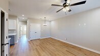 Located at 110 Peach Blossom Rd in Warner Robins, Georgia, this single-story, 3-bedroom, 2-bathroom home offers a clean, modern aesthetic with thoughtful finishes throughout. Warm-toned luxury vinyl plank flooring flows seamlessly across the entire living space, creating a cohesive and inviting atmosphere.

The living area is bright and open, featuring recessed lighting, a stylish ceiling fan with an integrated light fixture, and an elegant pendant chandelier that adds a refined touch. A set of arched double doors leads to a closet, adding classic architectural detail to the space. Natural light filters in through blinded windows, enhancing the home's airy feel.

The kitchen is well-equipped with white shaker cabinetry, light quartz countertops, an undermount sink with a matte black faucet, and a full suite of stainless steel appliances including a refrigerator, electric range, microwave, and dishwasher.

Each of the three bedrooms continues the consistent flooring and neutral color palette, with ceiling fans and windows that allow natural light to brighten the rooms. The spacious primary bedroom offers a comfortable retreat.

The bathrooms are clean and functional, featuring a tub-shower combination with matte black fixtures, a vanity with ample cabinetry, and light tile flooring. The home's cohesive design and modern finishes make it a move-in-ready option in Warner Robins.