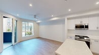 This thoughtfully designed single-floor residence offers a well-appointed 1-bedroom, 1-bathroom layout that maximizes every square foot with a clean, modern aesthetic throughout. Light hardwood-style flooring flows seamlessly across the open-concept living and kitchen areas, complemented by crisp white walls and recessed lighting that create a bright, airy atmosphere.

The kitchen is a standout feature, equipped with full-height white shaker cabinetry with matte black hardware, quartz countertops, a subway tile backsplash, and a suite of stainless steel appliances including a gas range, over-the-range microwave, and refrigerator. A central island provides additional prep and dining space, anchoring the kitchen to the open living area. A large window in the living room invites natural light and outdoor views, while a ceiling fan adds comfort.

The bedroom is a calm, well-proportioned retreat featuring its own window with natural light, a ceiling fan, and direct access to a dedicated walk-in closet with built-in shelving and hanging rods. The bathroom is finished with a white shaker vanity, quartz countertop, undermount sink, large wall mirror, and clean tile work. The overall design is cohesive, modern, and move-in ready.