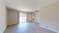 This single-floor residence offers a clean, contemporary layout designed for comfortable everyday living. The open living area is a standout feature, finished with light hardwood-style flooring that extends throughout the main spaces. A ceiling fan overhead and a large sliding glass door flood the room with natural light while providing direct access to the outdoors. Neutral warm-beige walls create a calm, versatile backdrop throughout the home.

The kitchen is thoughtfully appointed with wood-toned cabinetry, white quartz-style countertops, a stainless steel sink, and a white dishwasher. Adjacent to the kitchen is a dedicated laundry area, adding everyday convenience. White appliances, including a range, are neatly integrated into the kitchen's design.

The bedrooms are carpeted in a soft neutral tone, offering a comfortable and quiet retreat. Each room is generously sized with ample wall space and access to natural light through windows with blinds.

The bathrooms are finished with light hardwood-style flooring, white cabinetry with modern hardware, and a full tub-shower combination. Clean white fixtures and a well-organized vanity complete the look. Overall, the residence presents a move-in-ready interior with a cohesive, understated aesthetic throughout.