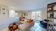 This single-floor residence offers a thoughtfully designed layout that blends comfort and modern style throughout. The open-concept living area is bright and welcoming, anchored by large sliding glass doors that invite natural light and provide access to an outdoor balcony with exterior views. Light hardwood-style flooring runs seamlessly throughout the main living spaces, complementing the neutral wall tones that give the home a clean, airy feel. A ceiling fan overhead adds both function and a casual design touch to the living space.

Adjacent to the living area, the dedicated dining space accommodates a round table and seating for four, accented by framed wall art and a ceiling fan. The kitchen features contemporary wood-grain cabinetry, white countertops, and a full suite of white appliances including a range, over-the-range microwave, dishwasher, and refrigerator — all finished with light flooring for a cohesive look.

The bedroom is generously sized with a double closet, a window with natural light, and neutral tones that create a calm retreat. The bathroom is finished with large-format tile flooring and wall surround, a sliding glass tub-shower enclosure, and a sleek white vanity with modern hardware. A closet with built-in storage rounds out the practical features of this well-balanced residence.