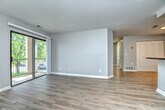 This single-floor, 2-bedroom, 1-bathroom residence offers a thoughtfully designed layout that makes efficient use of its space. The open living room serves as the heart of the home, featuring light wood-tone laminate flooring and a full-width sliding glass door that opens onto a private balcony with outdoor views, flooding the room with natural light.

The galley-style kitchen is well-equipped with white cabinetry, dark granite-style countertops, and black appliances including a gas range and refrigerator. A double-basin sink and dishwasher add everyday convenience, while wood-look flooring ties the space together seamlessly.

Both bedrooms are carpeted in neutral tones and finished with soft gray walls. The primary bedroom offers a generous footprint with a closet featuring louvered bifold doors, while the secondary bedroom includes a window with views of surrounding greenery. Each room provides a calm, understated retreat.

The bathroom is finished with wood-look flooring, a white vanity with brushed nickel hardware, and a full tub-shower combination with tile surround and coordinating fixtures. A dedicated in-unit laundry area with a top-loading washer and dryer and an overhead storage shelf adds practical convenience to complete this functional and comfortable home.