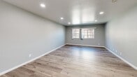 Located at 3313 N Maple Ave in Fresno, CA, this single-story, 3-bedroom, 2-bathroom home offers a thoughtfully updated interior with a cohesive modern aesthetic throughout. Light gray walls, crisp white trim, and wood-look luxury vinyl plank flooring run consistently across the entire home, creating a clean and unified feel.

The open-concept living, dining, and kitchen area serves as the heart of the home. The kitchen is outfitted with white shaker-style cabinetry, dark countertops, a stainless steel sink, and stainless steel appliances including a refrigerator and range. Recessed lighting illuminates the main living area, which also features a large window that invites natural light.

Each of the three bedrooms continues the same flooring and neutral palette. The primary bedroom offers a generous footprint, while the secondary bedrooms are well-proportioned and include windows with outdoor views and dedicated closets. Ceiling fans are present in multiple bedrooms for added comfort.

The two bathrooms are distinctly finished. One features a sleek walk-in shower enclosed in glass with large-format marble-look tile and a decorative mosaic border. The second bathroom includes a tub-shower combination with sliding glass doors, a white vanity, and matching wood-look flooring. Together, they reflect a clean, contemporary design sensibility.