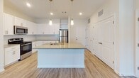 Located at 5895 Arbor Isle Way in Myrtle Beach, SC, this single-floor residence offers a clean, modern design with a bright and airy aesthetic throughout. The open-concept kitchen serves as a central gathering point, showcasing white shaker cabinetry, granite countertops, a large center island with pendant lighting, a subway tile backsplash, and a full suite of stainless steel appliances including a refrigerator, range, and microwave. Light wood-look flooring runs through the main living areas, lending warmth and continuity to the space.

The living room is generously proportioned, featuring plush carpeting, a ceiling fan, and a set of French doors that invite natural light and provide access to an outdoor area. Bedrooms are carpeted for comfort and include large windows that fill the rooms with natural light. Walk-in closets are outfitted with wire shelving systems, offering organized and practical storage solutions.

The primary bathroom is well-appointed with a dual-sink vanity topped with granite, a glass-enclosed shower, and light wood flooring. A secondary bathroom features a soaking tub and shower combination. Throughout the residence, crisp white walls, recessed lighting, and clean finishes create a fresh, move-in-ready environment ideal for comfortable coastal living.