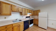 This single-floor unit offers a straightforward and functional layout, highlighted by gleaming hardwood floors that extend throughout the living areas and bedrooms, adding warmth and character to the space. The floor plan, as seen in the dollhouse view, flows openly between rooms, allowing for easy movement and versatile use of each area.

The kitchen is equipped with an abundance of warm oak cabinetry providing ample storage above and below the counters. It features a coil-top electric range, a black dishwasher, a white refrigerator, and a stainless steel sink — all arranged in an efficient layout along with light-toned laminate flooring that contrasts the wood-toned cabinetry.

The living areas and bedrooms are bright and open, with large windows fitted with blinds that allow natural light to filter in while maintaining privacy. Clean white walls pair with the rich hardwood floors to create a neutral, move-in-ready atmosphere. At least one bedroom includes a closet with double-panel doors, offering practical storage. The bathroom features a tub-shower combination with a window for natural ventilation and light.

Overall, the unit presents a clean, classic aesthetic with durable finishes and a practical layout suited for comfortable everyday living.