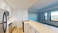 Located at 2150 N Lincoln Park West in Chicago's prestigious Lincoln Park neighborhood, this well-appointed single-floor residence offers a thoughtfully designed layout with modern finishes throughout. The updated kitchen is a standout feature, showcasing white shaker cabinetry with brushed gold hardware, a marble-look quartz countertop, a kitchen island with a built-in range, stainless steel appliances including a full-size refrigerator and dishwasher, and warm light hardwood-style flooring illuminated by recessed lighting. The kitchen opens to a connected living and dining area, where light wood-style floors and a neutral color palette create a clean, cohesive aesthetic. A pass-through window connects the kitchen to the adjacent dining space. The carpeted bedrooms are generously sized and fitted with ceiling fans, baseboard heating, and large black-framed windows that frame sweeping views of Lake Michigan and Lincoln Park — a truly remarkable feature. Additional living areas also benefit from these panoramic lake vistas. The bathroom is finished with classic cream tile, a white vanity, and a tub-shower combination. Throughout the residence, neutral tones, abundant natural light, and elevated lake views combine to create a bright, comfortable living environment in one of Chicago's most desirable neighborhoods.