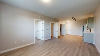 Located at 110 Cornell St in Kingston, NY, this thoughtfully designed 2-bedroom, 1-bathroom unit offers a clean, modern aesthetic throughout its single-floor layout. Light hardwood-style flooring extends seamlessly across every room, creating a bright and cohesive feel.

The open-concept kitchen and living area serves as the heart of the unit. The kitchen is outfitted with stainless steel GE appliances—including a range, microwave, dishwasher, and refrigerator—complemented by shaker-style cabinetry in a soft gray-green tone and crisp white countertops with a subway tile backsplash. The adjacent living area provides generous open space with a clean, neutral palette.

Both bedrooms feature neutral warm-gray walls, white trim, and panel doors with matte black hardware. The primary bedroom offers a comfortable footprint, while the second bedroom benefits from a large window with slatted blinds that allows abundant natural light and views of the surrounding neighborhood.

The full bathroom is finished in a modern style with a vanity, white countertop, and wood-tone flooring that continues from the rest of the unit. A standout convenience is the stacked in-unit washer and dryer located just off the bathroom. Throughout the space, the consistent use of neutral tones, clean lines, and contemporary finishes creates a functional and inviting living environment.