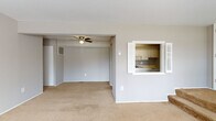 Located at 21255 Detroit Rd in Rocky River, Ohio, this single-floor unit offers a functional and straightforward layout designed for comfortable everyday living. The open living and dining area is finished with neutral-toned carpet and painted in a soft gray palette throughout, creating a cohesive and calm atmosphere. A ceiling fan adds practical comfort to the space, while an interior pass-through window connects the living area directly to the kitchen, enhancing the sense of openness between the two spaces. The kitchen features white cabinetry, a coil-burner electric range, a single-basin sink, ample counter space, and a full-size refrigerator, all set on durable tile flooring. The layout includes multiple carpeted bedrooms, each with natural light provided by windows fitted with blinds. One bedroom benefits from two windows, filling the room with an abundance of natural light and outdoor views of surrounding greenery. The bathroom is equipped with a white-tiled shower, a wood-trimmed vanity, and a classic patterned tile floor. Throughout the unit, consistent gray wall tones and clean white trim create a neutral backdrop well-suited to a variety of interior styles.