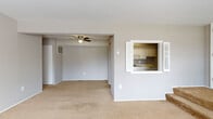 Located at 21255 Detroit Rd in Rocky River, Ohio, this single-floor unit offers a functional and straightforward layout designed for comfortable everyday living. The open living and dining area is finished with neutral-toned carpet and painted in a soft gray palette throughout, creating a cohesive and calm atmosphere. A ceiling fan adds practical comfort to the space, while an interior pass-through window connects the living area directly to the kitchen, enhancing the sense of openness between the two spaces. The kitchen features white cabinetry, a coil-burner electric range, a single-basin sink, ample counter space, and a full-size refrigerator, all set on durable tile flooring. The layout includes multiple carpeted bedrooms, each with natural light provided by windows fitted with blinds. One bedroom benefits from two windows, filling the room with an abundance of natural light and outdoor views of surrounding greenery. The bathroom is equipped with a white-tiled shower, a wood-trimmed vanity, and a classic patterned tile floor. Throughout the unit, consistent gray wall tones and clean white trim create a neutral backdrop well-suited to a variety of interior styles.