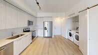 Located at 101 W Camino Real in Boca Raton, Florida, this well-appointed second-floor apartment offers a thoughtfully designed single-floor layout with one bedroom and one bathroom. Light wood-tone flooring flows consistently throughout the unit, creating a clean and cohesive aesthetic.

The kitchen is a standout feature, showcasing floor-to-ceiling light wood cabinetry, white quartz countertops, and a full suite of stainless steel appliances including an electric range, over-the-range microwave, dishwasher, and a large side-by-side refrigerator with ice and water dispenser. Track lighting overhead adds a modern touch. In-unit laundry is conveniently integrated, with a full-size Whirlpool front-loading washer and dryer tucked neatly into a dedicated alcove.

The bedroom is a comfortable, bright retreat featuring a ceiling fan, a large window with views of lush greenery, and direct access to a closet outfitted with multi-tier wire shelving for ample storage.

The bathroom is finished in neutral tones with large-format tile surrounding the soaking tub and shower combination, a sleek vanity with an undermount sink, and recessed lighting. A private balcony accessible from the main living area completes this well-rounded unit in the heart of Boca Raton.