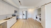 Located at 101 W Camino Real in Boca Raton, Florida, this well-appointed second-floor apartment offers a thoughtfully designed single-floor layout with one bedroom and one bathroom. Light wood-tone flooring flows consistently throughout the unit, creating a clean and cohesive aesthetic.

The kitchen is a standout feature, showcasing floor-to-ceiling light wood cabinetry, white quartz countertops, and a full suite of stainless steel appliances including an electric range, over-the-range microwave, dishwasher, and a large side-by-side refrigerator with ice and water dispenser. Track lighting overhead adds a modern touch. In-unit laundry is conveniently integrated, with a full-size Whirlpool front-loading washer and dryer tucked neatly into a dedicated alcove.

The bedroom is a comfortable, bright retreat featuring a ceiling fan, a large window with views of lush greenery, and direct access to a closet outfitted with multi-tier wire shelving for ample storage.

The bathroom is finished in neutral tones with large-format tile surrounding the soaking tub and shower combination, a sleek vanity with an undermount sink, and recessed lighting. A private balcony accessible from the main living area completes this well-rounded unit in the heart of Boca Raton.