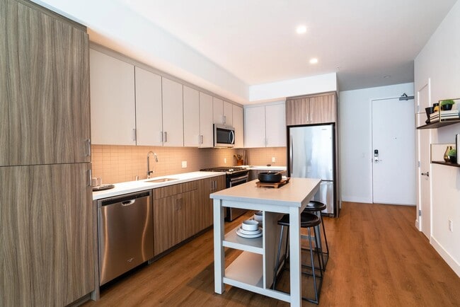 Kitchen with dual-tone cabinetry, stainless steel appliances, quartz surfaces, and a central island that adds flexibility for dining and meal prep. - Upper Ivy
