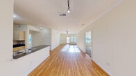 This well-appointed 3-bedroom, 2-bathroom single-story home offers a thoughtfully designed layout with a bright, open feel throughout. The main living and dining areas are connected in an open-concept arrangement, showcasing warm hardwood flooring, crown molding, and ceiling fans that enhance the airy ambiance. Large windows allow natural light to pour in, creating a welcoming atmosphere across the main living space.

The kitchen is efficiently designed with dark granite countertops, a mosaic tile backsplash, white cabinetry, and black appliances including a refrigerator, range, and microwave. A peninsula with an integrated sink adds both functionality and additional workspace.

The three bedrooms offer comfortable accommodations, with carpet flooring and ceiling fans in each. The primary bedroom includes a spacious walk-in closet outfitted with wire shelving and hanging rods. The two bathrooms feature hardwood floors, granite-topped vanities, and tiled tub-shower combinations.

Additional highlights include three closets for generous storage, a utility room, and a balcony that extends the living space outdoors. A hallway connects the rooms efficiently, completing this practical and comfortable floor plan.