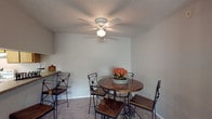 This single-floor residence features a thoughtfully arranged layout across two bedrooms and two bathrooms. The kitchen is equipped with warm wood-tone cabinetry, laminate countertops, a double stainless steel sink, and white appliances, including a range with overhead ventilation. A pass-through counter connects the kitchen to the adjacent dining area, which is accented by a ceiling fan with light fixture and offers a welcoming atmosphere for casual meals.

The dining space flows naturally into the carpeted living areas, which are neutral in tone and receive natural light through windows fitted with blinds and vertical treatments. Both bedrooms feature plush carpet flooring, neutral wall colors, textured ceilings, and windows that allow natural light to filter in, creating comfortable, versatile spaces.

The bathrooms are well-appointed, with one featuring a granite-style vanity countertop, a large mirror, and a tub-shower combination. The second bathroom includes a walk-in closet accessible from a carpeted hallway, adding practical storage to the layout. Throughout the residence, textured ceilings, clean white trim, and a consistent neutral color palette create a cohesive and understated aesthetic.