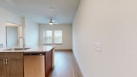 This 2-bedroom, 2-bathroom residence offers a thoughtfully designed single-floor layout that maximizes functionality and comfort. The open-concept kitchen serves as the heart of the home, featuring rich dark cabinetry, granite countertops, stainless steel appliances including a dishwasher and microwave, and a peninsula with an undermount sink — all flowing seamlessly into the living and dining area. Light wood-tone flooring runs throughout the unit, creating a warm and cohesive aesthetic. The living area benefits from natural light provided by double windows dressed with blinds, and is complemented by a ceiling fan with integrated lighting. The primary bedroom is a comfortable retreat with double doors leading to a dedicated closet and direct access to its own bathroom. The second bedroom is bright and clean, featuring the same light flooring and neutral walls, making it highly adaptable. Both bathrooms are finished with granite-topped vanities and warm wood cabinetry, maintaining a consistent design language. A hallway connects the private areas of the home efficiently. The overall palette of crisp white walls, warm wood floors, and brushed nickel hardware gives the space a clean, contemporary feel throughout.