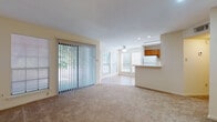 This single-floor, 1-bedroom, 1-bathroom residence offers a functional and open layout designed to maximize usable space. The living area serves as the heart of the home, featuring neutral-toned carpet, recessed lighting, and a ceiling fan overhead. A large sliding glass door fitted with vertical blinds floods the space with natural light while providing outdoor access. Multiple windows further brighten the room, creating an airy, open atmosphere.

The kitchen is positioned adjacent to the living area, connected via a pass-through counter that enhances the open feel. Warm-toned wood cabinetry lines the galley-style kitchen, complemented by tile flooring, white appliances including a full-size refrigerator, and a dedicated pantry with built-in shelving for ample storage.

The bedroom is a comfortably sized, carpeted retreat featuring a ceiling fan, generous wall space, and a large double window that invites natural light and outdoor views. The bathroom includes a full-size soaking tub and shower combination with clean white finishes. Throughout the residence, neutral wall tones and consistent design elements contribute to a cohesive, understated aesthetic that provides a versatile foundation for personalizing the space.