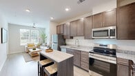 Located at 4824 Walmsley Blvd in Richmond, VA, this well-appointed one-bedroom, one-bathroom apartment offers a thoughtfully designed layout across a single floor. The living room is bright and welcoming, featuring a ceiling fan, wood-style flooring, and a window that draws in natural light and outdoor views, creating a comfortable and airy atmosphere. The kitchen is a functional highlight, showcasing rich dark-brown cabinetry reaching toward the ceiling, granite countertops, a full suite of stainless steel appliances including a refrigerator, electric range, microwave, and dishwasher, and a kitchen island for added prep space. The bedroom is a calm, light-filled retreat with a large window offering outdoor views, a ceiling fan, wood-style flooring, and direct access to the bathroom. The bathroom is well-equipped with dark wood cabinetry, a granite vanity countertop, a tall storage tower cabinet, and a large mirror illuminated by overhead lighting. A dedicated closet provides additional storage. Throughout the unit, clean white walls, consistent wood-style flooring, and brushed nickel hardware create a cohesive, modern aesthetic.