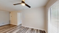 Located at 501 Branard St in Houston's vibrant Montrose neighborhood, this single-floor, one-bedroom, one-bathroom unit offers a thoughtfully designed layout with contemporary finishes throughout. The living area features smooth, neutral-toned walls, wood-look laminate flooring, and a ceiling fan with integrated lighting. Large sliding glass doors and windows invite natural light and provide outdoor views, creating a bright and airy atmosphere. The kitchen is well-appointed with crisp white shaker cabinetry, dark countertops, a light blue subway tile backsplash, and a suite of stainless steel appliances including a refrigerator, dishwasher, and microwave. A matte black faucet and undermount sink add a modern accent. The bedroom is a comfortable, well-lit space with the same wood-look flooring, a ceiling fan, and a large window overlooking the outdoors. A dedicated closet provides practical storage. The bathroom is a standout feature, showcasing a fully tiled walk-in shower enclosed by sleek glass doors with matte black hardware, complemented by vertical subway tile walls and a pebble-style shower floor. The unit also benefits from its prime location in one of Houston's most walkable and culturally rich neighborhoods.