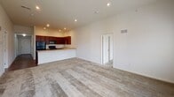 Located at 100 Cindy Dr in Newark, Delaware, this single-floor residence offers a well-designed layout with a clean, contemporary aesthetic throughout. A welcoming hallway with rich dark hardwood flooring and crisp white walls leads into the main living areas, setting a polished tone from the moment you enter. The kitchen is a functional highlight, featuring rich mahogany-toned cabinetry, light countertops, a full suite of black appliances including a refrigerator, range, microwave, and dishwasher, and recessed lighting that illuminates the space. The elevated ceiling in the kitchen area enhances the sense of openness. Adjacent to the kitchen, the living area is generously proportioned with soft carpeting, recessed lighting, and a door providing direct access to an outdoor deck, allowing natural light to fill the room. The bedrooms are carpeted and well-lit by multiple windows with blinds, offering comfortable, quiet retreats. The primary bedroom features impressive ceiling height and direct access to both a private en-suite bathroom and a walk-in closet. The bathrooms are clean and functional, with tiled flooring and combinations of shower stalls and tub/shower units. Overall, this residence provides a practical and comfortable single-level living experience in a residential Newark neighborhood.