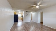 Located at 7901 N Loop Dr in El Paso, TX, this single-floor unit offers a straightforward and functional layout designed for comfortable everyday living. The main living area is generously proportioned, featuring durable wood-look flooring that runs throughout the unit, a textured ceiling, and a ceiling fan with integrated lighting that provides both airflow and illumination. The open sight line from the living area toward the kitchen and hallway creates a connected feel across the floor plan.

The galley-style kitchen is efficiently arranged with warm-toned wood cabinetry, black appliances including a full-size refrigerator and range, a double sink, and a window that allows natural light to brighten the space. A textured ceiling and cinder block wall construction give the kitchen a solid, durable character consistent throughout the unit.

The bedrooms continue the wood-look flooring and feature painted cinder block walls along with windows fitted with blinds that filter natural light. Each room provides a clean, neutral backdrop well-suited for a variety of uses.

The bathroom includes a single-sink vanity with wood cabinetry, a combination tub and shower, and a window for ventilation. The overall design of the unit emphasizes practicality and durability, with consistent materials and finishes tying each room together cohesively.