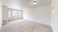 Situated in the heart of downtown Rochester, Minnesota, this single-floor residence offers a functional and well-organized layout with a clean, neutral aesthetic throughout. The living areas are finished with plush wall-to-wall carpeting and textured ceilings, creating a warm and comfortable atmosphere. Multiple windows frame elevated views of the surrounding cityscape, allowing natural light to fill the space and providing a connection to the vibrant urban environment outside.

The galley-style kitchen is efficiently designed with ample cabinetry in light wood tones, generous countertop space, a double-basin sink, and full-size appliances including a refrigerator and stove. Durable wood-look flooring runs through the kitchen and extends into adjoining utility areas, offering both practicality and visual continuity.

The bedrooms are carpeted and well-proportioned, each featuring windows with city views and closet storage, including a bifold-door closet with a built-in rod and shelf system. The bathroom is appointed with a full tub and shower combination, a wood-tone vanity, and matching wood-look flooring.

A dedicated laundry area provides added convenience with a stacked washer and dryer unit alongside additional shelving. The overall layout, as seen in the floor plan overview, flows intuitively, making efficient use of every area within the residence.