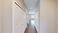 Located at 3300 Ann Arbor Saline Rd in Ann Arbor, Michigan, this well-appointed one-bedroom, one-bathroom unit offers a thoughtfully designed single-floor layout. The open living area features rich hardwood-style flooring and a large multi-pane window that floods the space with natural light, creating a bright and welcoming atmosphere.

The modern kitchen is a standout feature, outfitted with sleek white upper cabinetry paired with light wood lower cabinets, light-toned stone countertops, and a full suite of stainless steel appliances including a range, microwave, and refrigerator. A window above the counter adds additional natural light to the cooking space.

A well-proportioned hallway connects the main living areas to the private bedroom and bathroom, lined with ample closet storage on both sides. The bedroom is carpeted for comfort and includes a window with outdoor views, providing a calm and restful retreat.

The bathroom is clean and functional, featuring wood-look flooring, a glass-enclosed walk-in shower, a white vanity with storage, and a toilet. The neutral color palette throughout — warm greiges, crisp whites, and natural wood tones — contributes to a cohesive, contemporary aesthetic across the entire unit.
