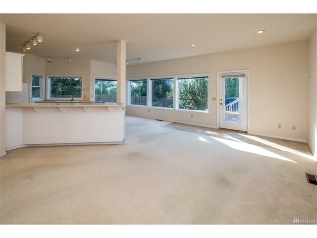 Looking from the family room toward the eating bar with the kitchen and dining area beyond. There is a large deck that takes in the views just outside the door. - 2809 Eldridge Avenue
