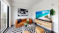 Located at 501 NW Seventh Terrace in Fort Lauderdale, FL, this thoughtfully designed one-bedroom, one-bathroom unit offers a compact yet efficient single-floor layout with modern finishes throughout. The open-concept living, dining, and kitchen area serves as the heart of the home, anchored by large floor-to-ceiling windows that flood the space with natural light and frame views of the surrounding neighborhood and Fort Lauderdale skyline. The kitchen features sleek, flat-panel cabinetry in a warm wood tone paired with white upper cabinets, stainless steel appliances, a subway tile backsplash, and clean white countertops. Wide-plank wood-look flooring runs throughout, adding warmth and continuity. A hallway connects the living area to the private bedroom, which includes a sliding double-panel closet and a cozy, well-proportioned layout. The bathroom is finished with large-format gray wall tiles, a soaking tub with shower, a floating wood vanity, and white countertops, giving it a clean, spa-inspired feel. Additional features include two closets, an in-unit laundry area, and recessed lighting throughout. The overall aesthetic is crisp, contemporary, and efficiently organized.