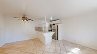 Located at 501 Michigan Blvd in West Sacramento, California, this one-bedroom, two-bathroom unit offers a practical and efficiently designed single-floor layout. The open-concept living area seamlessly connects the dining space and kitchen, creating a bright, airy atmosphere enhanced by natural light streaming through the windows and large diagonal-set ceramic tile flooring underfoot. A ceiling fan adds comfort to the main living area.

The kitchen features a wraparound tile-topped breakfast bar that separates it from the living space while maintaining an open feel. Stainless steel appliances — including a gas range, microwave, and refrigerator — are complemented by a tiled backsplash and white cabinetry, offering both function and a clean aesthetic. Built-in open shelving provides additional storage.

The bedroom is carpeted for warmth and comfort, fitted with a ceiling fan with light fixture, a sliding-door closet, and a window with an outdoor neighborhood view. Two bathrooms serve the unit; one features a full tub-shower combo with warm-toned tile surround and matching tile flooring, while the other includes a white vanity with under-cabinet storage, a mirrored medicine cabinet, tiled backsplash, and a built-in open shelving unit for extra storage. Two closets throughout the unit offer ample organizational space.