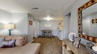 Located at 2115 Park Springs Cir in Arlington, TX, this single-floor, 2-bedroom, 2-bathroom residence offers a functional and comfortable layout across a efficiently designed footprint. The open-concept living and dining area forms the heart of the home, featuring warm wood-look flooring, neutral gray walls, and a textured ceiling throughout. The living room provides access to a private patio through sliding glass doors, bringing in natural light and outdoor connectivity. The dining area flows seamlessly into the kitchen, which is equipped with stainless steel appliances, a black refrigerator, white cabinetry, granite-style countertops, a tile backsplash, and a convenient pantry. Both bedrooms are carpeted and include ceiling fans and dedicated closets. The generously sized primary bedroom features an en-suite bathroom with a granite-style vanity and access to a walk-in closet. The second bedroom is well-proportioned with a large window. The second bathroom includes a full tub-shower combination with white tile surround and a matching vanity. Additional highlights include a hallway connecting the private areas, in-unit laundry, and ample storage throughout.