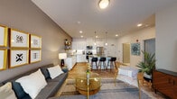Located at 15 Poplar St in Glassboro, NJ, this single-floor unit offers a thoughtfully designed open-concept layout with warm wood-look flooring throughout. The living area is bright and welcoming, featuring a sliding glass door that fills the space with natural light and provides direct access to an outdoor patio. A hallway adorned with vibrant botanical artwork connects the main living spaces, adding a stylish touch to the interior.

The kitchen is a standout feature, outfitted with crisp white shaker cabinetry, granite countertops, and a full suite of stainless steel appliances including a range, microwave, and refrigerator. Rustic open wood shelving adds character, while a multi-seat island with bar stools creates a natural gathering spot for dining and entertaining. Pendant lighting above the island enhances the kitchen's modern aesthetic.

The living room features a bold accent wall and sheer curtain-framed patio doors, creating a cozy yet open atmosphere. The bedroom is a serene retreat with soft neutral tones, hardwood-style flooring, and ample space for furnishings. The bathroom is clean and functional, offering a vanity with white cabinetry, a walk-in shower, and tile flooring. This unit combines contemporary finishes with practical design throughout.