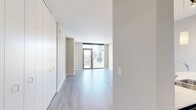 Located in Chicago's vibrant West Loop neighborhood, this one-bedroom, one-bathroom residence offers a thoughtfully designed layout with contemporary finishes throughout. Light gray hardwood-style flooring flows seamlessly across the open living space, anchored by expansive floor-to-ceiling windows and a glass balcony door that frames sweeping city skyline views and floods the interior with natural light.

The open-concept kitchen, dining, and living area serves as the heart of the home. The kitchen is outfitted with dark espresso cabinetry, stainless steel appliances including a gas range, microwave, and French door refrigerator, a light-colored glass tile backsplash, and a generous marble-veined quartz breakfast bar with pendant lighting overhead — ideal for both casual dining and entertaining.

The bedroom is a comfortable retreat, benefiting from its own access to the balcony and city views through large windows, complemented by an extensive built-in closet system. Four closets throughout the unit provide ample storage. The bathroom features large-format white tile flooring, dark vanity cabinetry with a white countertop, and a full soaking tub with dark gray tile surround. Neutral tones and clean lines throughout give the entire space a polished, modern character.