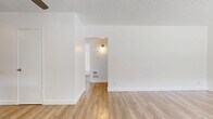 Located at 1011 E Palmer Ave in Glendale, CA, this single-floor 2-bedroom, 1-bathroom unit offers a clean, modern aesthetic throughout. Light wood-style flooring flows continuously across all rooms, creating a warm and cohesive atmosphere. The kitchen is well-equipped with white shaker-style cabinetry, dark countertops, stainless steel appliances including a gas range and full-size refrigerator, and a window above the sink that draws in natural light. The combined kitchen and living area provides a functional, open layout suited for everyday living. The primary bedroom is a comfortable size and features a ceiling fan, a large window with views of the surrounding outdoor area, and a wall AC unit. The second bedroom is bright and airy, with natural light streaming through slatted blinds and views of mature trees outside. Additional rooms offer similar clean, white-walled finishes with the same warm flooring. The bathroom includes a full tub and shower combination with white tile surround, a small window for ventilation, and straightforward, functional fixtures. Textured ceilings are present throughout, adding a subtle architectural detail. The overall ambiance of the space is bright, clean, and move-in ready.