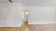 Located at 1011 E Palmer Ave in Glendale, CA, this single-floor 2-bedroom, 1-bathroom unit offers a clean, modern aesthetic throughout. Light wood-style flooring flows continuously across all rooms, creating a warm and cohesive atmosphere. The kitchen is well-equipped with white shaker-style cabinetry, dark countertops, stainless steel appliances including a gas range and full-size refrigerator, and a window above the sink that draws in natural light. The combined kitchen and living area provides a functional, open layout suited for everyday living. The primary bedroom is a comfortable size and features a ceiling fan, a large window with views of the surrounding outdoor area, and a wall AC unit. The second bedroom is bright and airy, with natural light streaming through slatted blinds and views of mature trees outside. Additional rooms offer similar clean, white-walled finishes with the same warm flooring. The bathroom includes a full tub and shower combination with white tile surround, a small window for ventilation, and straightforward, functional fixtures. Textured ceilings are present throughout, adding a subtle architectural detail. The overall ambiance of the space is bright, clean, and move-in ready.