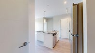 Located at 235 Willis Cres in Saskatoon, Saskatchewan, this modern 2-bedroom, 2-bathroom unit offers a thoughtfully designed open-concept layout with contemporary finishes throughout. Light wood-style flooring flows seamlessly across the entire space, complementing the bright, neutral colour palette.

The kitchen serves as a striking centerpiece, featuring a large granite-topped island with an integrated sink and dishwasher, bold veining that adds visual drama to the clean, modern aesthetic. White cabinetry extends to the ceiling, providing ample storage, while stainless steel appliances — including a refrigerator, electric range, and over-the-range microwave — complete the well-equipped space. Pendant lighting and a track light system illuminate the kitchen and adjoining living area. In-unit laundry is also conveniently tucked nearby.

Both bedrooms are generously proportioned and filled with natural light. The primary bedroom features a large floor-to-ceiling window with views of the surrounding neighbourhood and access to a private balcony. The second bedroom benefits from a bright window with pleasant outdoor views. Each bedroom includes a dedicated closet.

The two bathrooms are finished with granite countertops, white cabinetry, and clean tile work, with one featuring a full tub-shower combination. The unit also includes two closets for additional storage throughout.