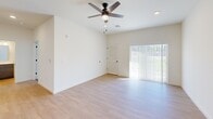 Located in Maiden, NC, this thoughtfully designed single-story home offers a well-utilized layout that includes a combined kitchen and living area, one bedroom, one bathroom, and a dedicated laundry room. The open-concept living area is bright and airy, featuring light luxury vinyl plank flooring and a ceiling fan with a sliding glass door that invites abundant natural light and provides views of the surrounding greenery outside.

The kitchen is a standout feature, outfitted with dark espresso cabinetry, quartz countertops, and a full suite of stainless steel appliances including a range, over-the-range microwave, refrigerator, and dishwasher. A peninsula with an undermount sink and pendant lighting above creates a functional and stylish space for both cooking and casual dining.

The bedroom is a comfortable retreat with soft carpeting, a double-door closet, and a window for natural light. The bathroom is clean and practical, featuring a full tub/shower combo with chrome fixtures and wood-look flooring. The dedicated laundry room accommodates a full-size top-load washer and dryer with overhead wire shelving for additional storage. Clean white walls and consistent finishes throughout give this home a cohesive, move-in-ready feel.