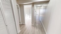 Located on the top floor of a building along Macleod Trail S in Calgary, this two-bedroom, one-bathroom penthouse unit offers a comfortable and functional layout finished with light wood-style flooring and neutral tones throughout. Two hallways connect the spaces efficiently, contributing to a logical and easy-to-navigate floor plan.

The combined kitchen and living area forms the heart of the unit. The kitchen is well-equipped with stainless steel appliances—including a refrigerator, electric range, and dishwasher—complemented by ample taupe cabinetry, tile backsplash, and generous counter space. The adjacent living area is bright and open, featuring large sliding glass doors that lead to an outdoor balcony, allowing abundant natural light to fill the space and offering views of the surrounding Calgary cityscape.

Both bedrooms are well-lit, each featuring large windows with vertical blinds and closets with louvered doors. The primary bedroom benefits from corner windows that maximize natural light and outdoor views.

The bathroom is finished in neutral tones, featuring a tiled tub-shower combination with grab bars, a vanity with storage, and a large mirror. A textured ceiling is consistent throughout the unit, adding a classic character to the overall aesthetic.