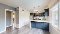 Located at 621 E 99th St in Inglewood, CA, this 2-bedroom, 2-bathroom residence offers a thoughtfully designed single-floor layout with modern finishes throughout. The open kitchen and living area serves as the heart of the home, featuring bold navy-blue cabinetry, stainless steel appliances including a refrigerator, range, and microwave, white quartz countertops with a subway tile backsplash, a peninsula with pendant lighting, and light wood-look flooring that extends seamlessly throughout the space. Natural light pours in through multiple windows, enhancing the bright and airy atmosphere. Both bedrooms are comfortably proportioned, each showcasing wood-look flooring, neutral gray accent walls, ceiling fans, and windows with outdoor views of the surrounding neighborhood. The primary bedroom includes a mirrored sliding closet, while a separate room provides convenient in-unit stacked washer and dryer access. The two bathrooms are finished with large-format stone-look tile, including a soaking tub with a glass sliding door enclosure and dark cabinetry vanities with white countertops. Hallways connect the rooms efficiently, completing this well-organized and move-in-ready home in the heart of Inglewood.
