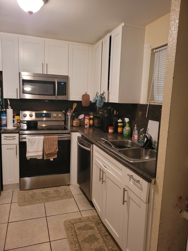 Kitchen with full shaker cabinets and stainless steel appliances - 4215 N University Dr