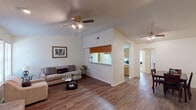 This single-story, two-bedroom, two-bathroom residence in College Station, Texas offers a well-organized layout designed for comfortable everyday living. The living room serves as the heart of the space, featuring warm wood-look flooring, vaulted ceilings, and a striking full-height brick fireplace flanked by windows that allow natural light to filter in. A ceiling fan overhead adds to the room's functionality, while a pass-through window connects the living area to the kitchen, enhancing the open feel.

The galley-style kitchen is lined with warm wood cabinetry on both sides, providing ample storage, and includes a white electric range, a sink, and generous counter space. It opens directly into a dedicated dining area, complete with its own ceiling fan.

Both bedrooms are carpeted and generously proportioned, each with ceiling fans and closet space. One bedroom features sliding closet doors and windows overlooking the exterior. The two bathrooms are practical in design, each with a vanity and shower/tub combination.

A connecting hallway with wood-look flooring ties the layout together, offering a cohesive flow throughout the residence. Overall, the space presents a functional and comfortable living environment suited for a variety of occupants.
