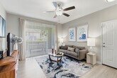 Located at 7450 Northrop Dr in Riverside, CA, this single-story, 2-bedroom, 2-bathroom home offers a thoughtfully designed layout with a clean, contemporary aesthetic throughout. Light wood-look flooring flows through the main living areas, complemented by neutral gray walls and ceiling fans that enhance the airy feel.

The open-concept living, dining, and kitchen area serves as the heart of the home. The living room features a large sliding glass door dressed with vertical blinds and drape panels, providing access to a private patio and filling the space with natural light. The adjacent dining area offers an intimate setting, while the kitchen impresses with white shaker cabinetry, speckled gray countertops, stainless steel appliances including a gas range, microwave, and refrigerator, and a single-basin sink with a window above.

Both bedrooms are carpeted and well-sized, with the generously proportioned primary bedroom offering notable space. Each bedroom is served by ceiling fans and ample closet storage, including a walk-in closet with wire shelving systems. The two bathrooms are finished with white vanity cabinetry, wide mirrors, and a tub-shower combination. Additional conveniences include a dedicated laundry area and a hallway connecting the private quarters to the main living spaces.