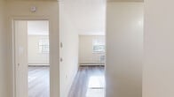 Located at 1600 Garrett Rd in Upper Darby, PA, this one-bedroom, one-bathroom unit offers a practical and well-organized layout across a single floor. Light-toned luxury vinyl plank flooring runs throughout, lending a clean, cohesive look to each room. Neutral cream-colored walls and textured ceilings create a bright, airy atmosphere.

The living room provides a comfortable open area bathed in natural light, with a window fitted with blinds and a baseboard heating system along the perimeter. The bedroom is a well-proportioned space featuring its own window with outdoor views, a wall-unit air conditioner, baseboard heat, and a built-in closet with paneled doors — offering convenient, dedicated storage. A second closet is accessible from the hallway, adding further organizational flexibility.

The kitchen connects efficiently to the main living areas, while the hallway ties the layout together with a logical flow between rooms. The bathroom is tastefully appointed with white square tile wainscoting, a white vanity with under-cabinet storage, brushed nickel hardware, an undermount sink with solid countertop, and a large mirror with overhead lighting — delivering a clean and functional finish. Overall, this unit presents a straightforward, well-maintained space suited for comfortable everyday living.