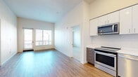 Located at 471 26th Street in Oakland, CA, this modern residence offers 3 bedrooms and 3 bathrooms across a thoughtfully designed single-floor layout. The open-concept kitchen and living area serves as the heart of the home, featuring soaring ceilings that amplify the sense of space. The kitchen is outfitted with stainless steel appliances — including an electric range, built-in microwave, and dishwasher — complemented by two-tone cabinetry with white upper cabinets and wood-grain lower cabinets, and clean white countertops. Wood-style plank flooring runs throughout the main living areas, adding warmth and continuity. The living room benefits from large windows that invite abundant natural light and provide outdoor views. The three bedrooms are carpeted for comfort, each featuring neutral walls and windows with blinds. Closet space is available in the bedroom areas. The bathrooms are clean and functional, with white vanities, large mirrors, and wood-style flooring; one bathroom includes a full soaking tub with shower. A hallway connects the private quarters to the main living space, ensuring a practical and efficient flow throughout the residence.