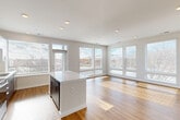 Located at 2500 Vantage Dr in Woodbridge, VA, this well-appointed single-floor residence offers 3 bedrooms, 3 bathrooms, and a thoughtfully designed open-concept layout. The combined living, dining, and kitchen area serves as the heart of the home, bathed in natural light from an impressive array of large windows along multiple walls. Warm hardwood-style flooring runs throughout the main living spaces, complementing the clean, modern aesthetic. The kitchen features a central island with a crisp white countertop, two-tone cabinetry with dark lower cabinets and white upper cabinets, stainless steel appliances including a range, microwave, and dishwasher, and a single-basin sink beneath a sun-drenched window. The primary bedroom is generously sized with hardwood-style flooring and expansive corner windows offering broad outdoor views. The two additional bedrooms are carpeted and well-lit with large windows and ceiling fans. Six closets, including walk-in options with wire shelving systems, provide ample storage throughout. The bathrooms are finished in a clean, contemporary style with white tile surrounds, soaking tubs, and sleek floating vanities. A dedicated laundry room adds everyday convenience to this modern Woodbridge residence.